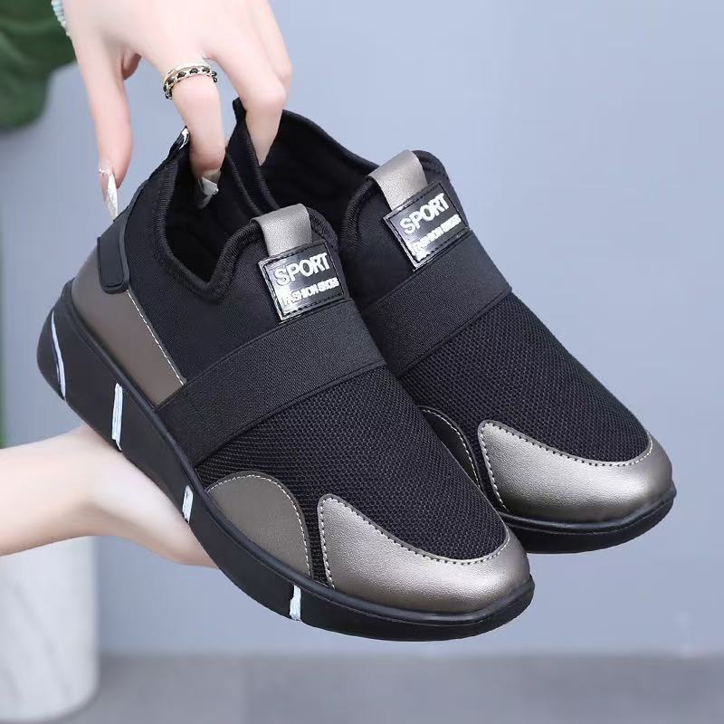 Black slip-on sneakers with metallic gold/gray panels and sport patch at tongue