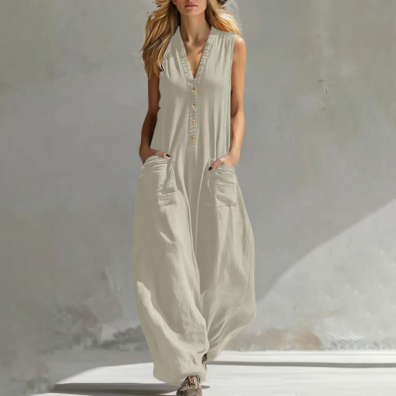 White sleeveless wide-leg jumpsuit with V-neck button front and side pockets.