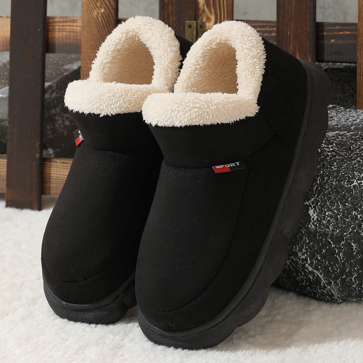 Black plush house shoes with fuzzy strap and thick white sole, back view