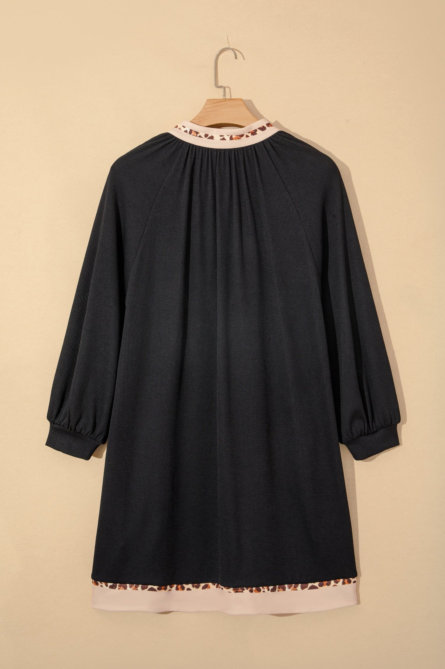 Black ribbed dress on hanger, back yoke with contrast hem and leopard trim