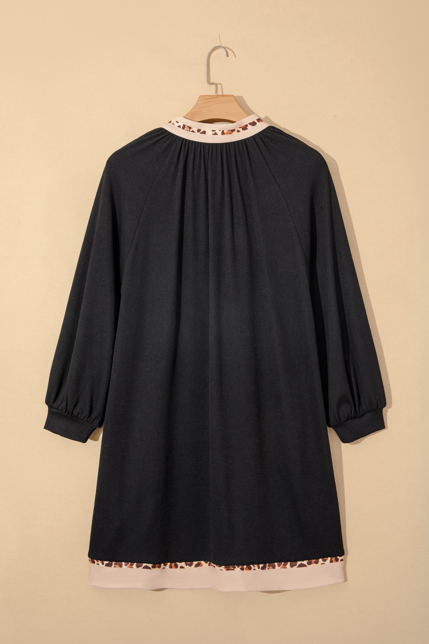 Black ribbed dress on hanger, back yoke with contrast hem and leopard trim