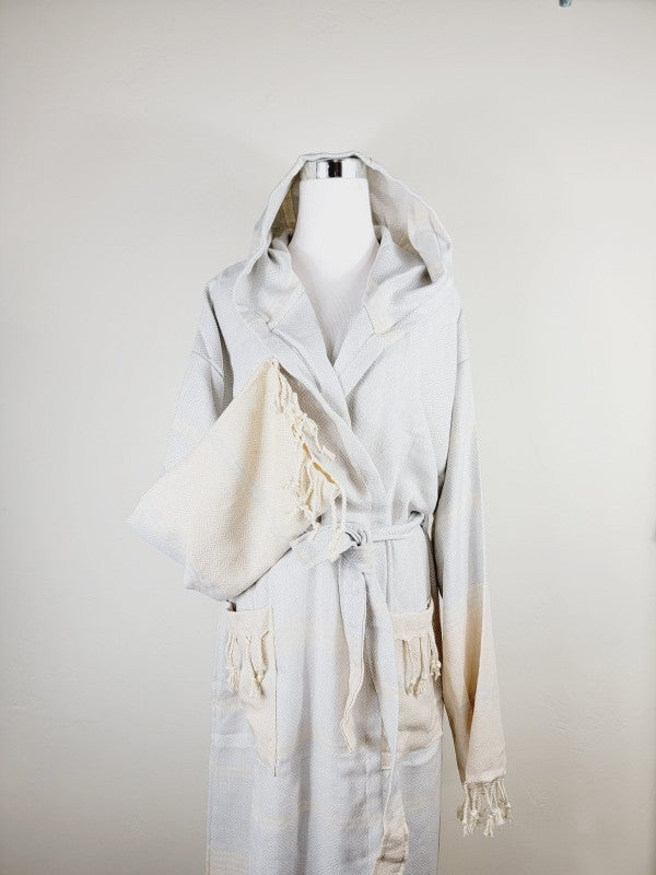 Off-white hooded robe with tie belt, patch pockets, and tassel-trim cuffs