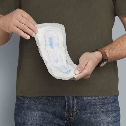 White men’s incontinence guard held against the body