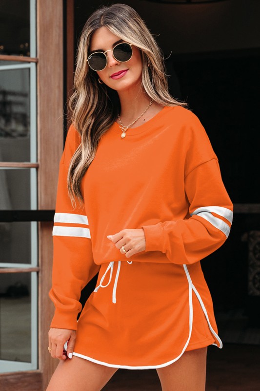 Orange pullover and mini skirt set with white stripe cuffs and drawstring waist ties.