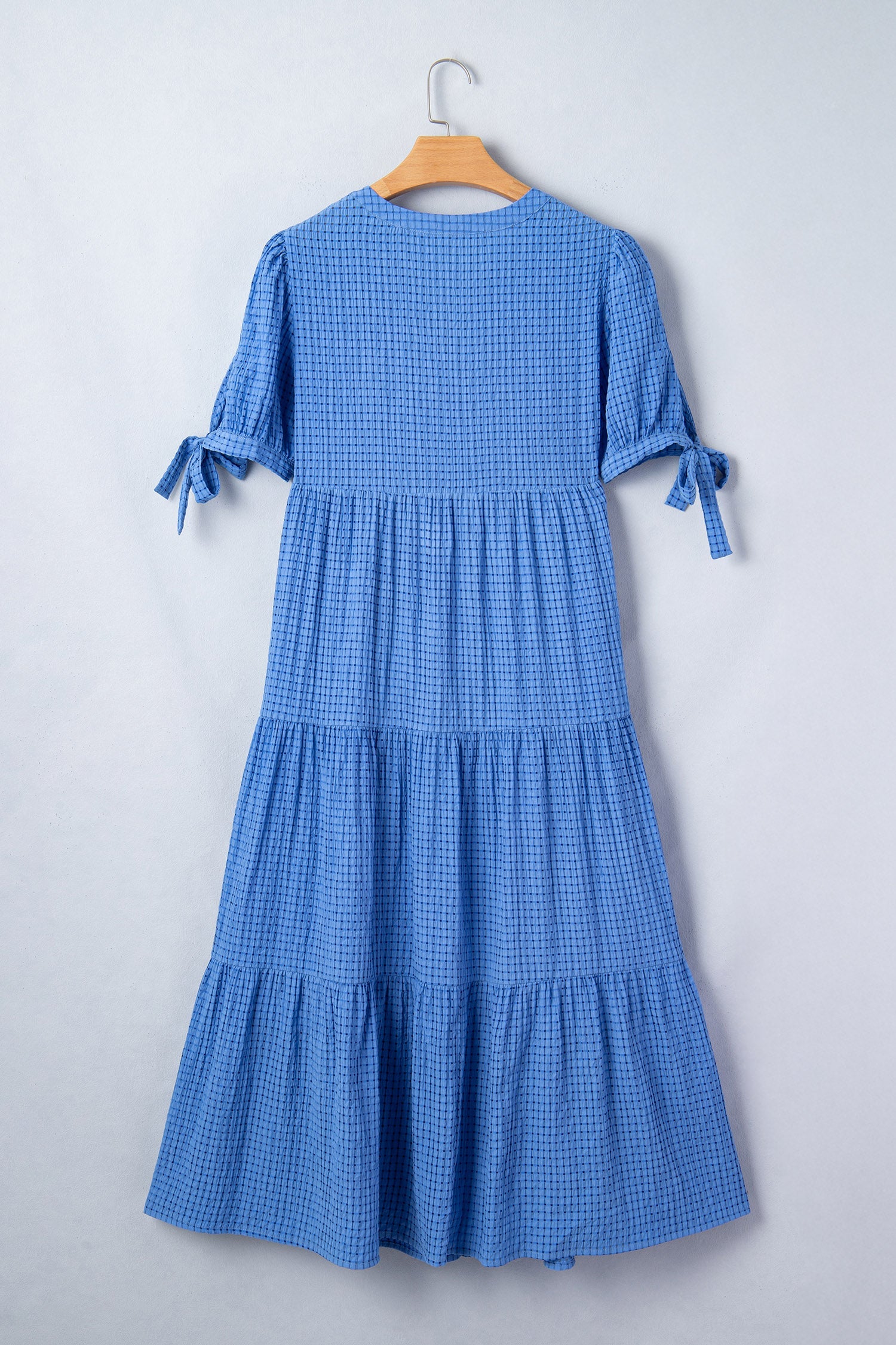 Dusk blue tiered midi dress back view on hanger with gathered tier skirt