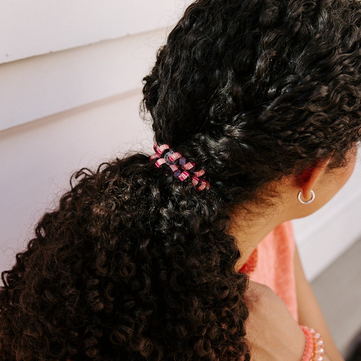 Coral and pink check large hair ties on curly dark hair