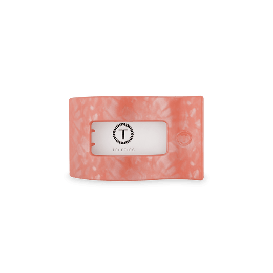 Peach flat rectangle hair clip with rectangular opening and embossed brand mark