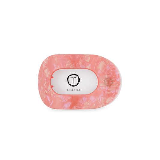 Pink flat oval hair clip with underside logo panel and black bar prongs