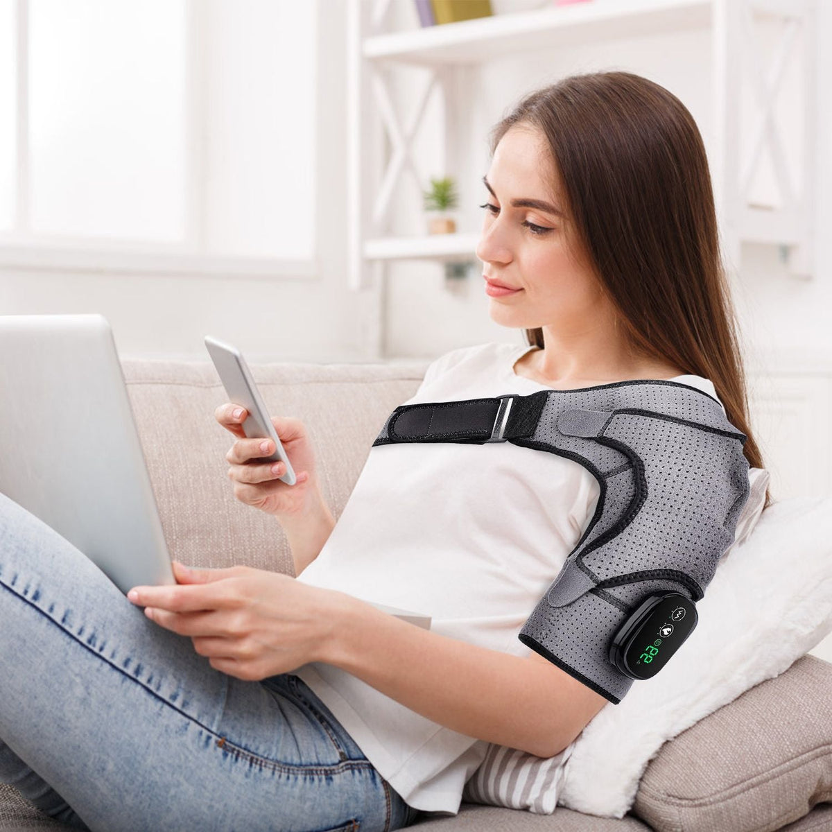 Grey cordless heated shoulder wrap worn on a shoulder with controller