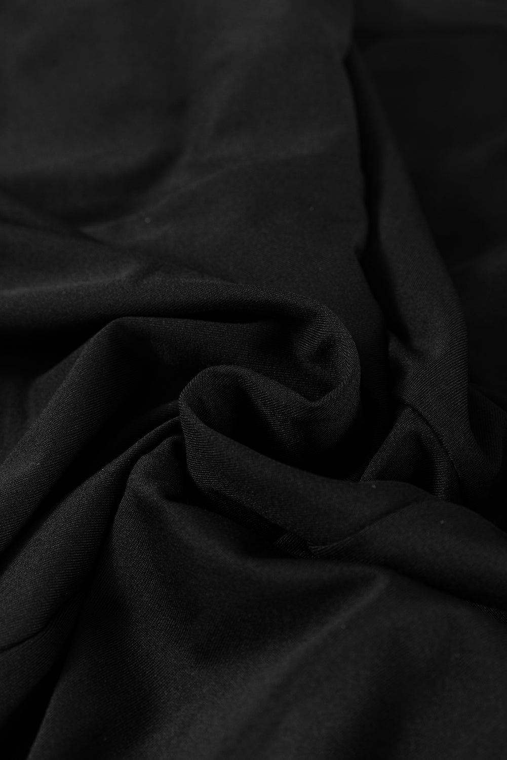 Black dress fabric texture close-up with soft drape