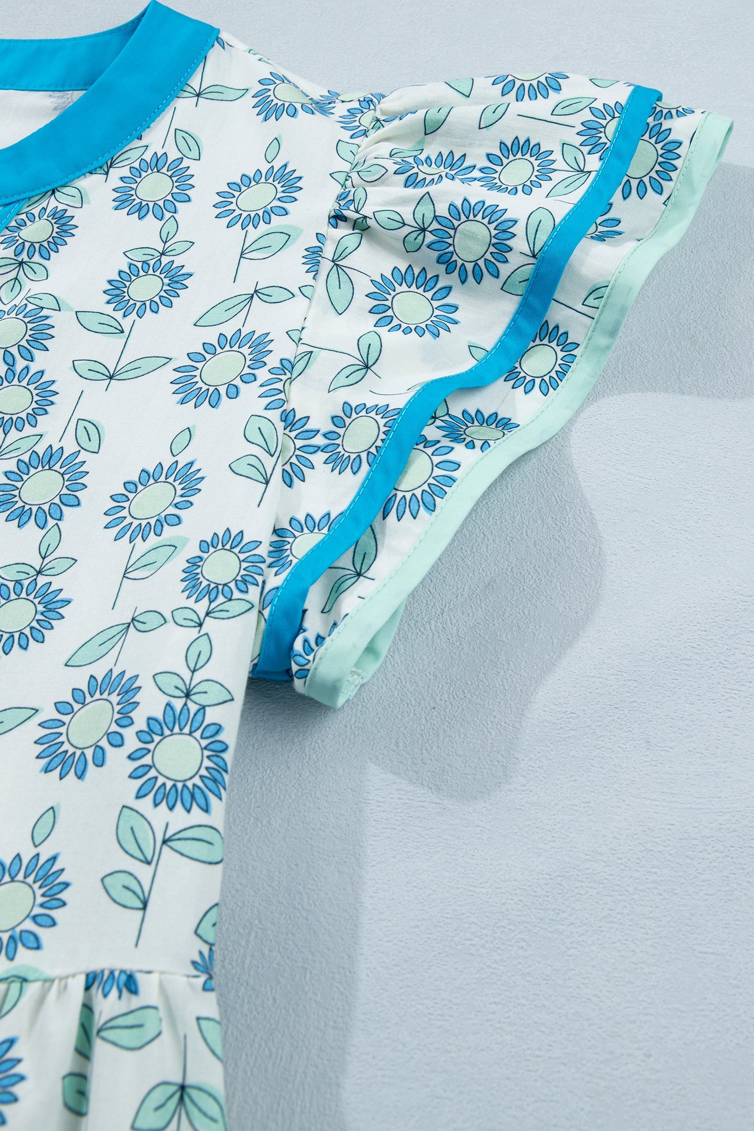 Sky blue mini dress with flutter sleeves and blue daisy floral print, ruffled hem