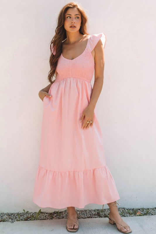Apricot pink maxi dress with smocked bodice, flutter sleeves, and tiered skirt