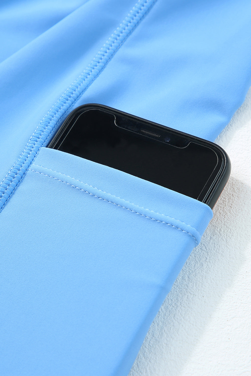 Dusk blue lined swim dress side pocket holding a smartphone