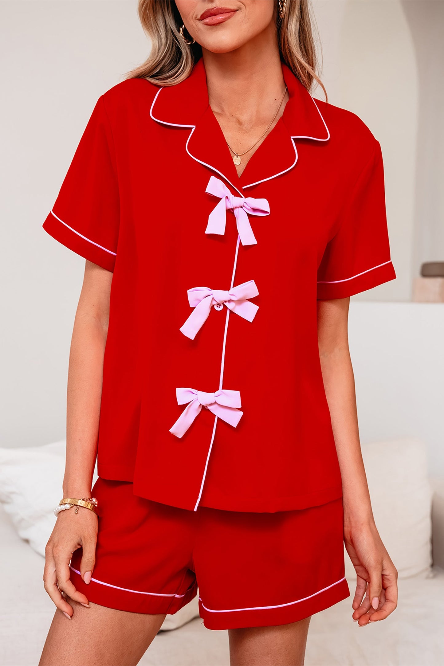 Red silky pajama top and shorts set with bow-tie placket and contrast piping trim