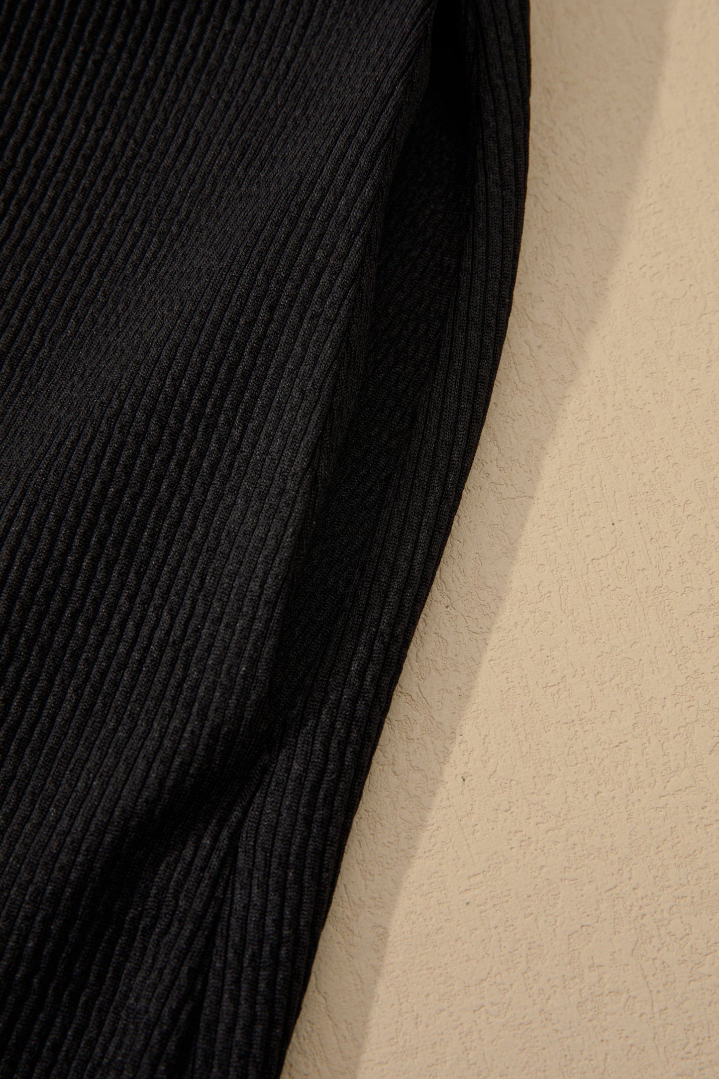 Black ribbed sleeve fabric panel with textured vertical rib detail