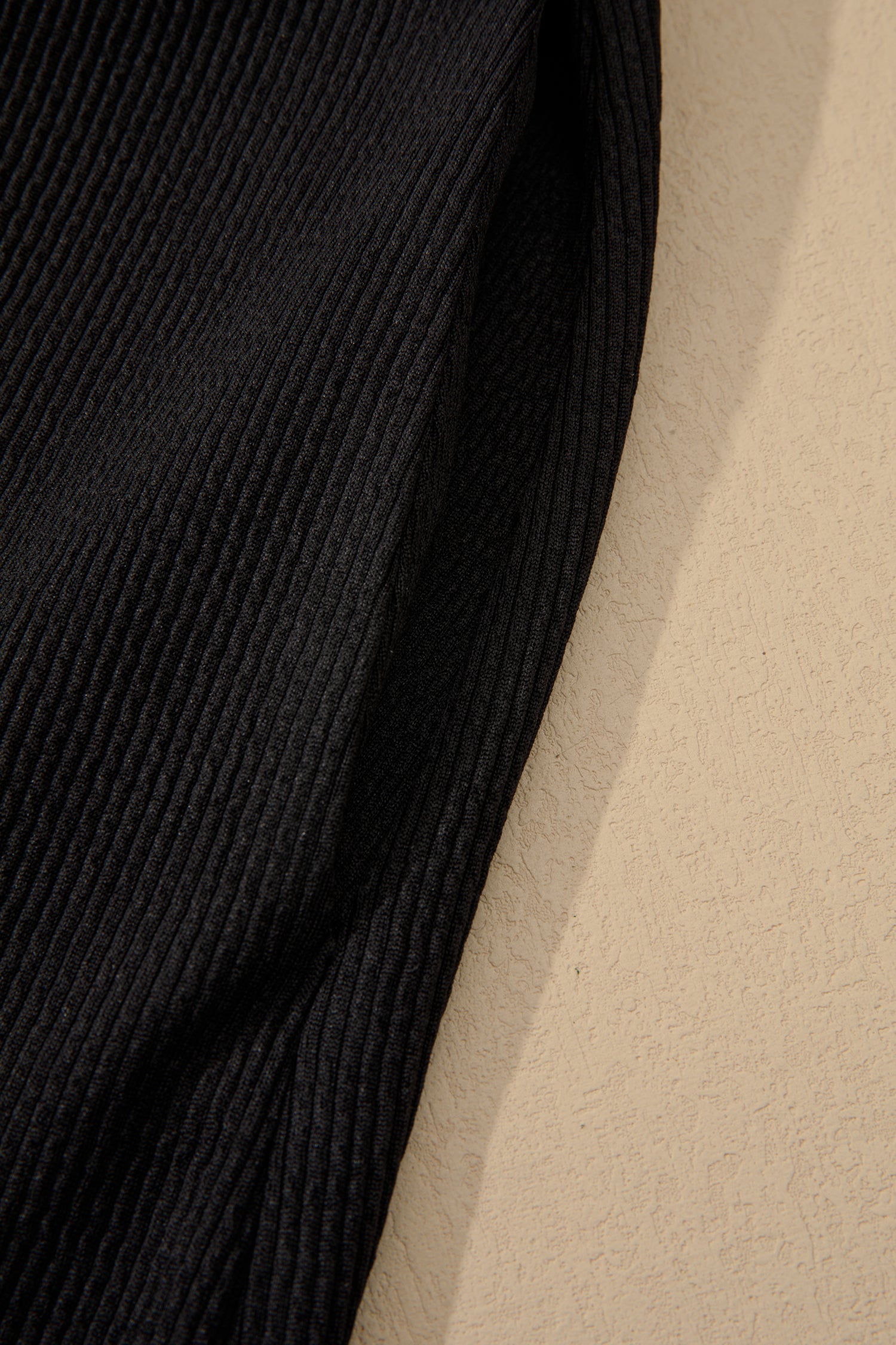 Black ribbed sleeve fabric panel with textured vertical rib detail