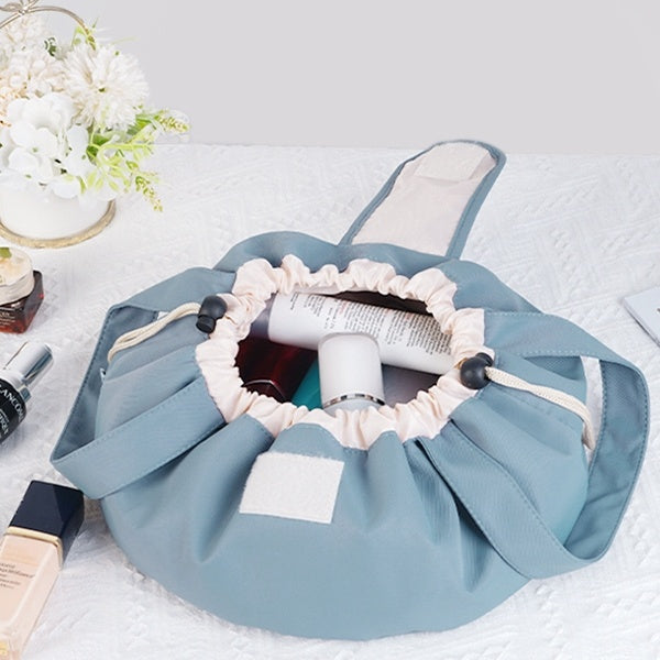 Sky blue drawstring makeup bag, open top with elastic ruffle and toiletries inside