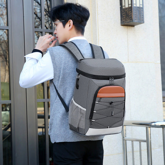 Gray insulated backpack bag with orange front panel, black trim, and zippered top pocket