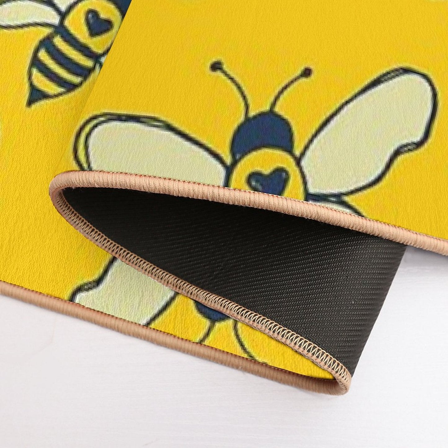 Side view of bee bath mat edge with dark underside and stitched trim
