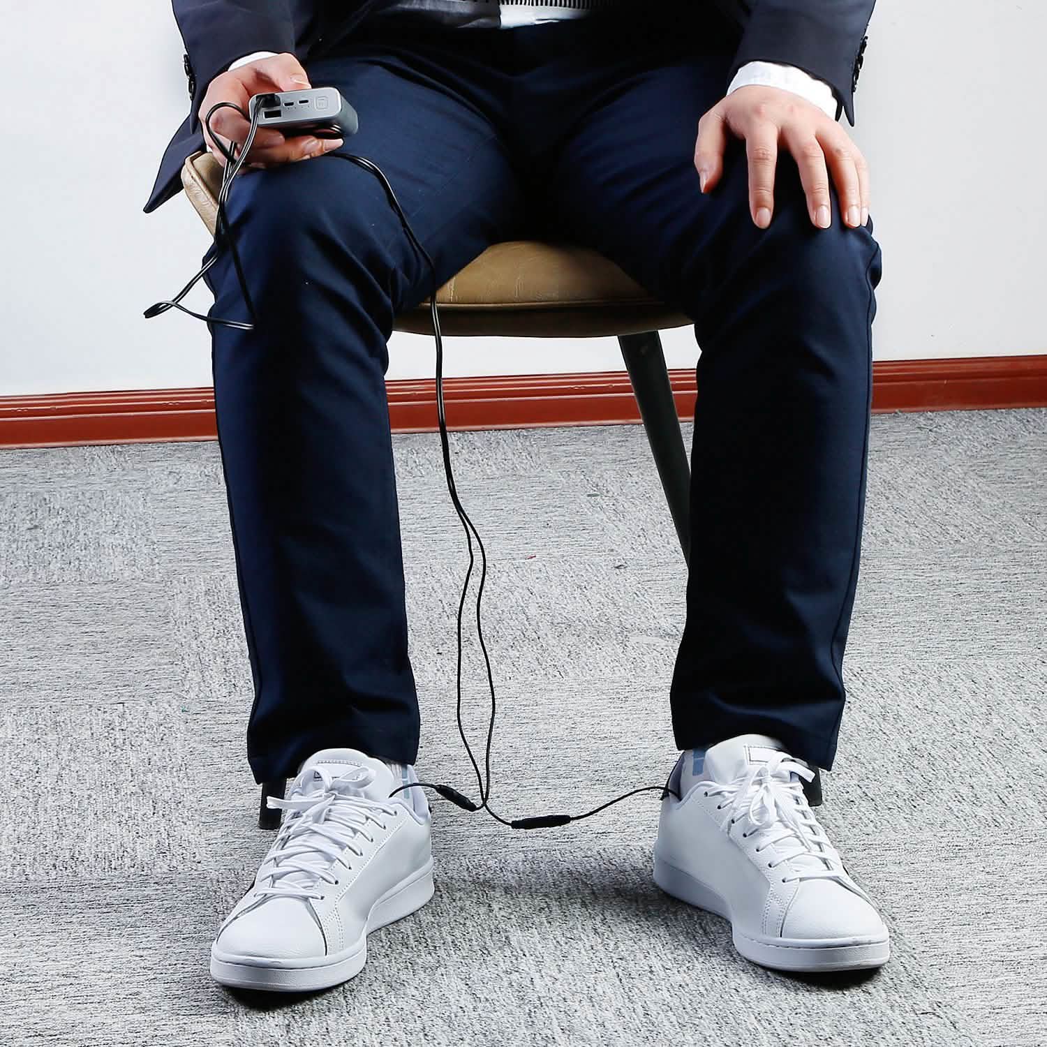 Heated insole system in white sneakers with USB controller connected by cable