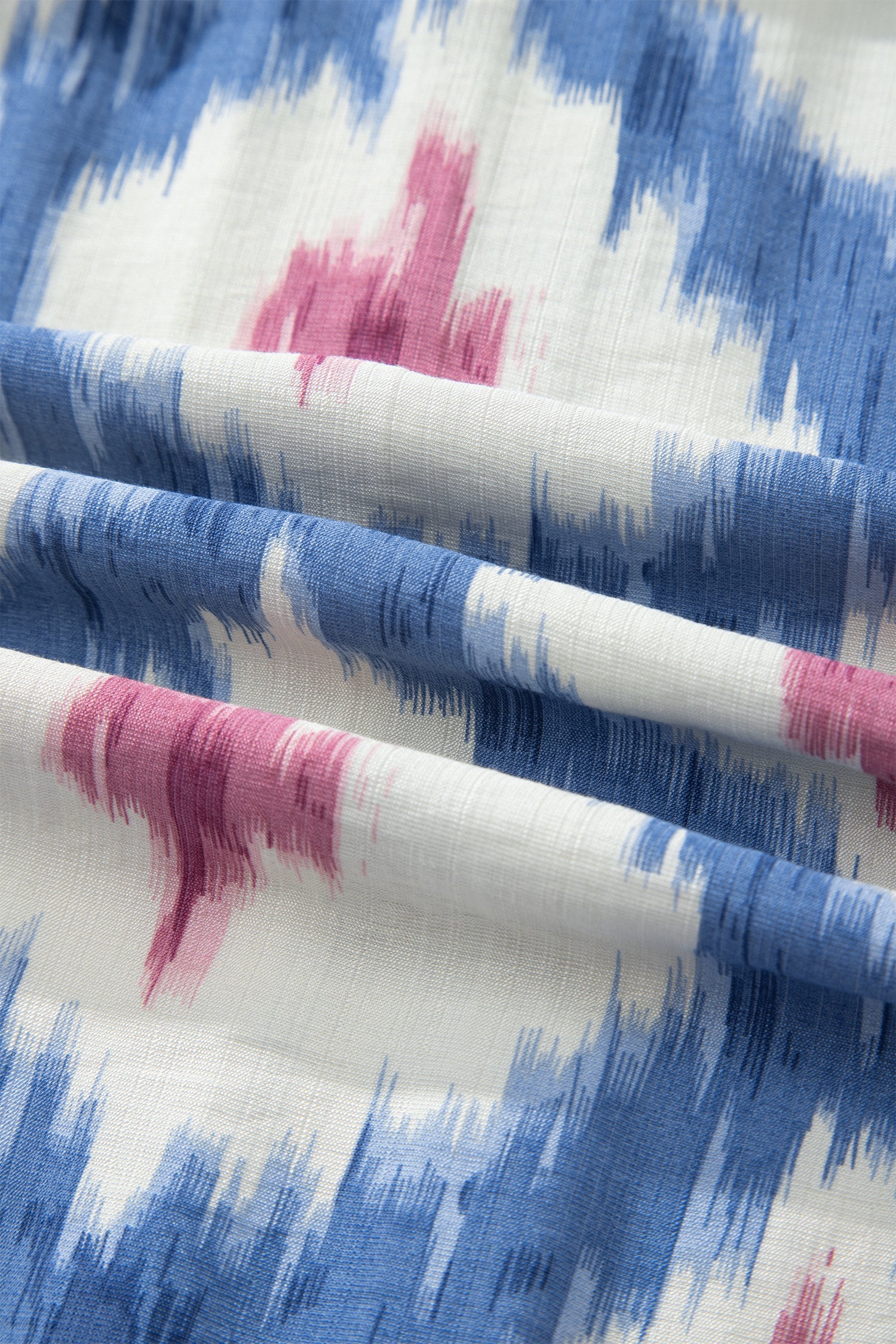 Sky-blue and white fabric with pink brushstroke print, ruffle dress close-up.