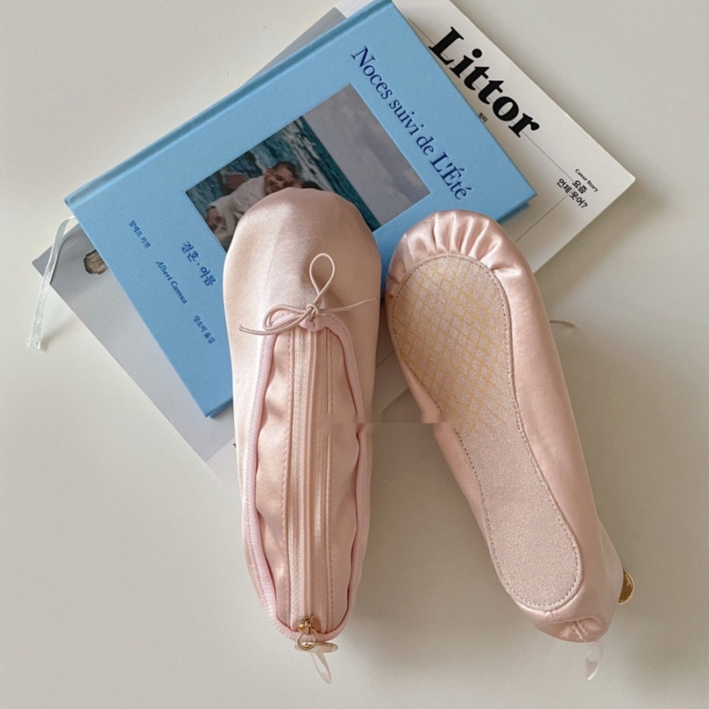 Pink satin ballet shoe makeup bag with lace-up bow and gold zipper pull