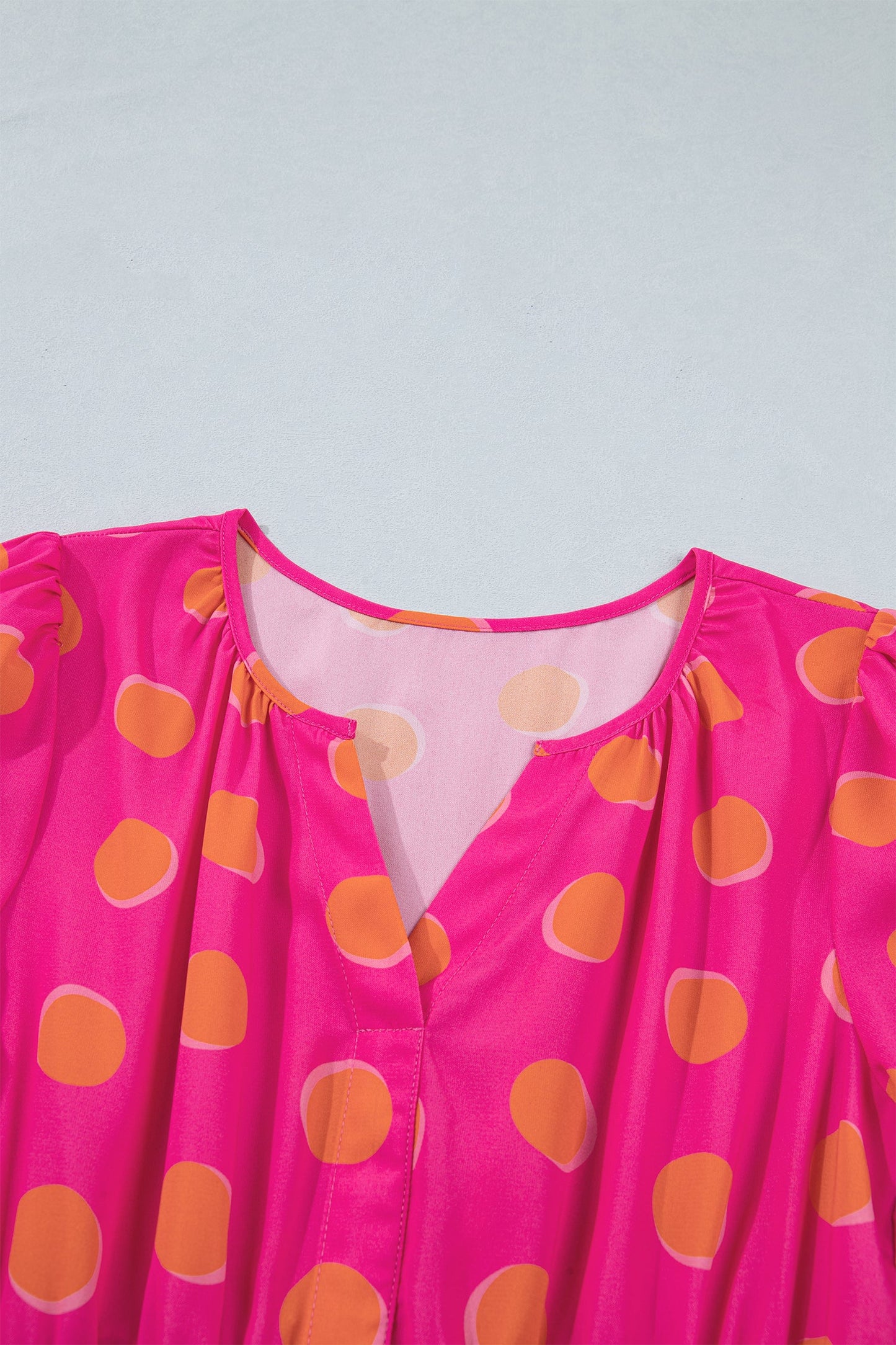 Rose dress bodice close-up with V-cut neckline and yellow dot print