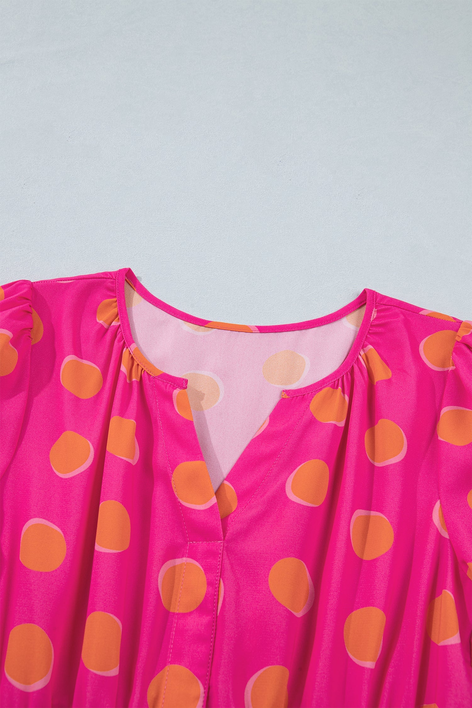 Rose dress bodice close-up with V-cut neckline and yellow dot print