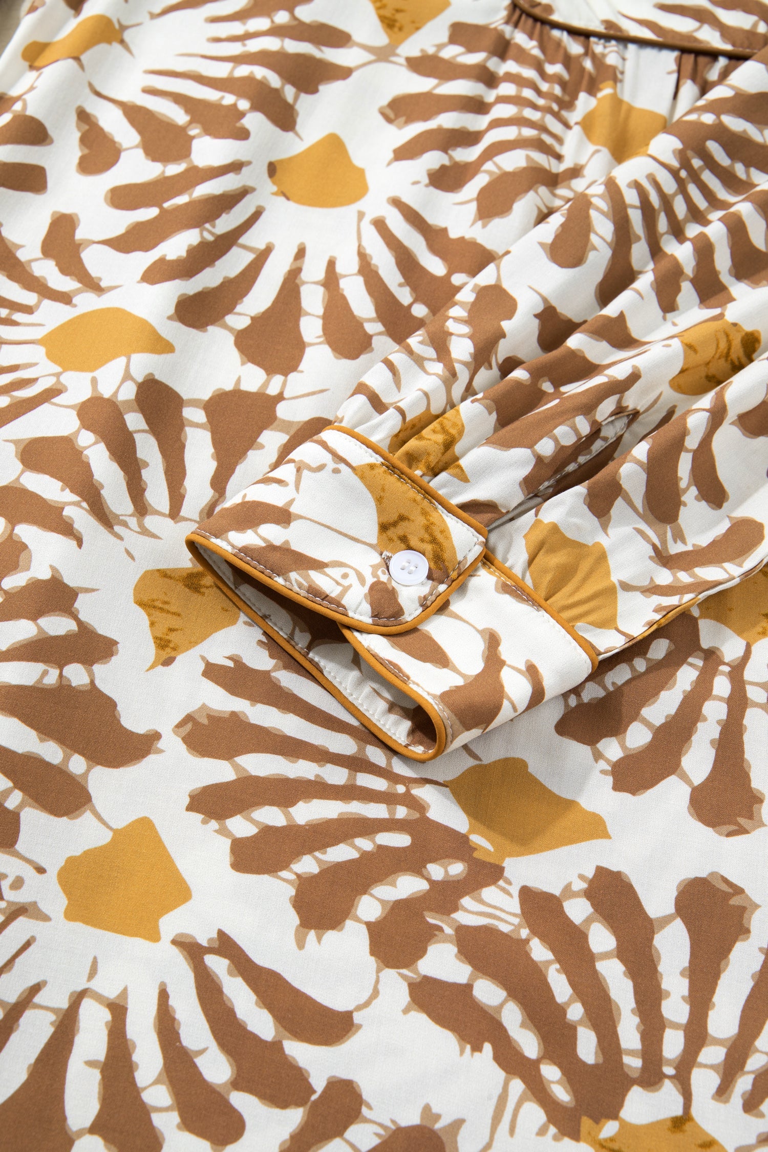 Loose long plus dress with tie detail at waist and abstract brown-and-yellow print.
