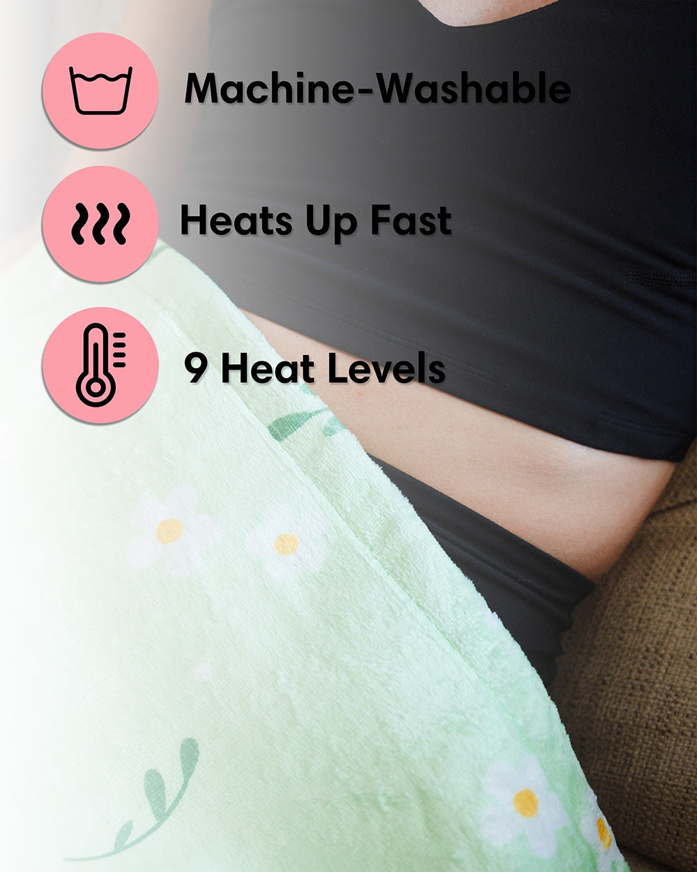 Mint green heating pad corner on bed with floral print, visible control heat settings graphic