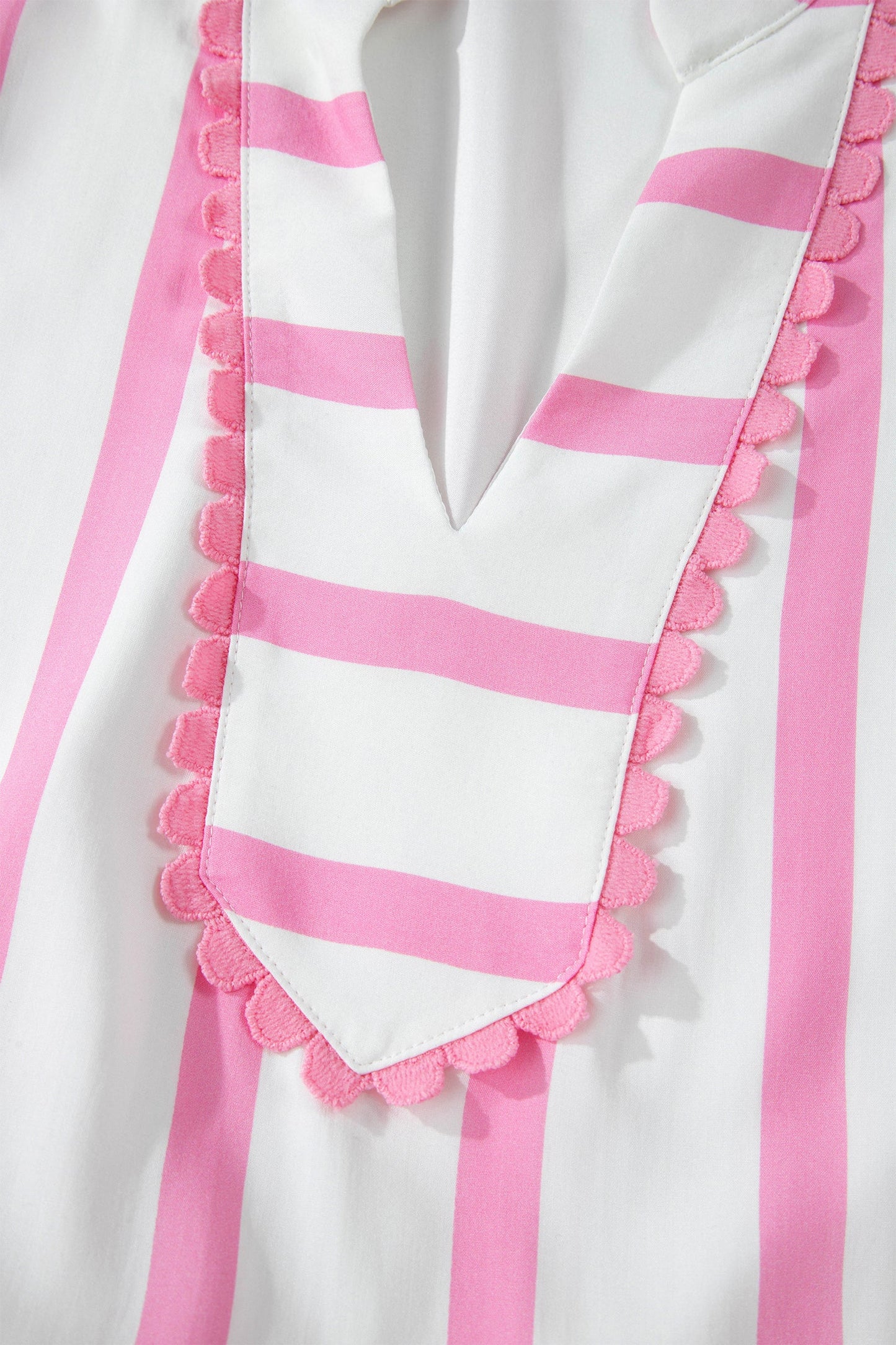 Close-up of scalloped pink-striped ruffle front panel with button accents