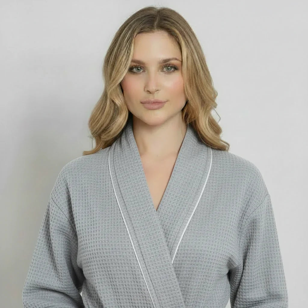 Women’s knee-length waffle robe in light grey with white piping, V-neck and belt tie