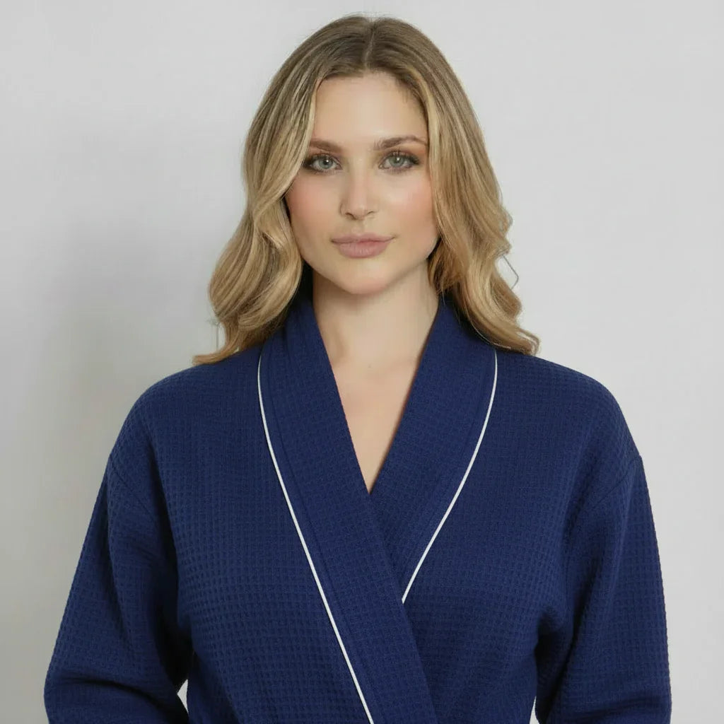 Women’s knee-length waffle robe in navy with white piping, V-neck and belt tie