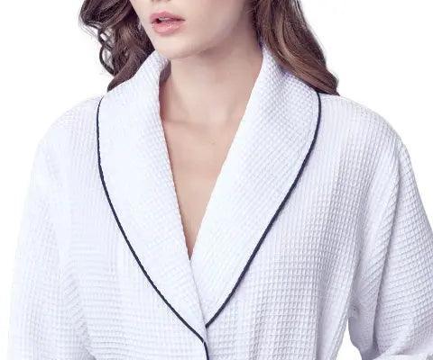 Women’s waffle bathrobe in white with dark piping, V-neck collar detail.
