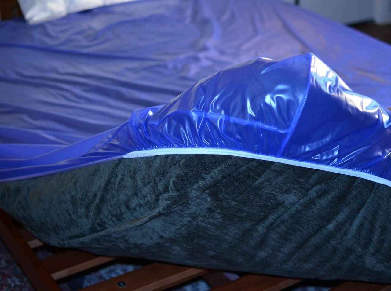 Sapphire blue plastic mattress protector with zipper along the mattress edge
