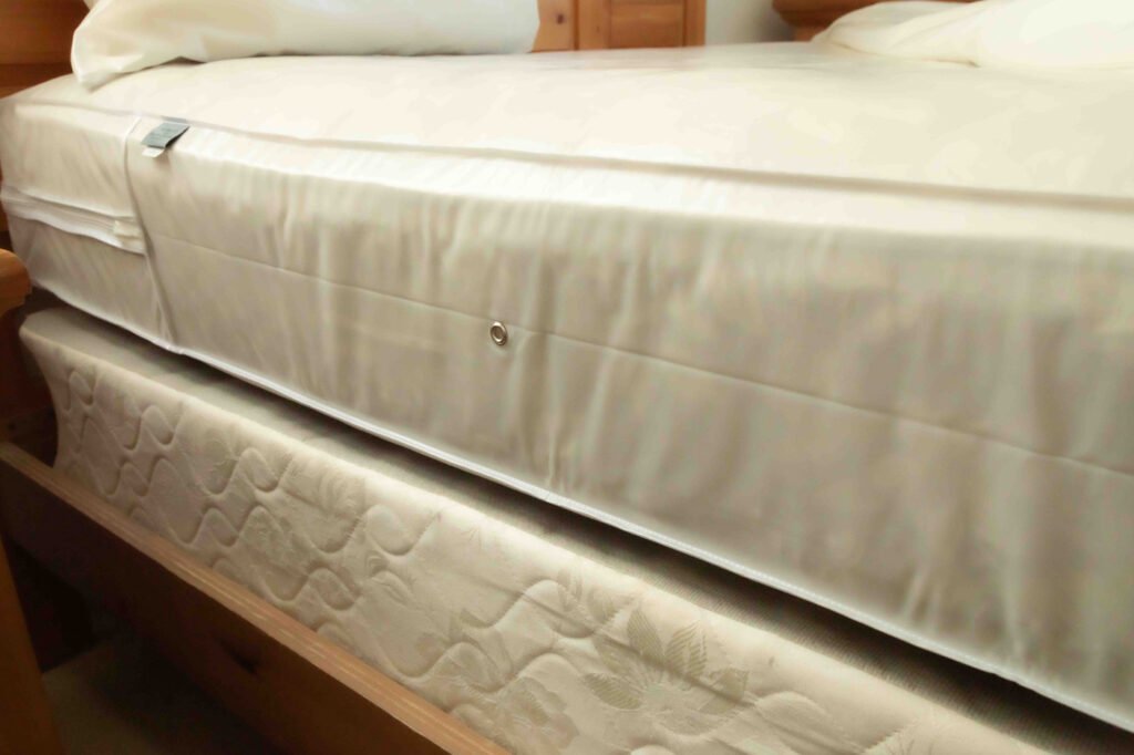 Milky white mattress cover protector fitted over bed mattress corners