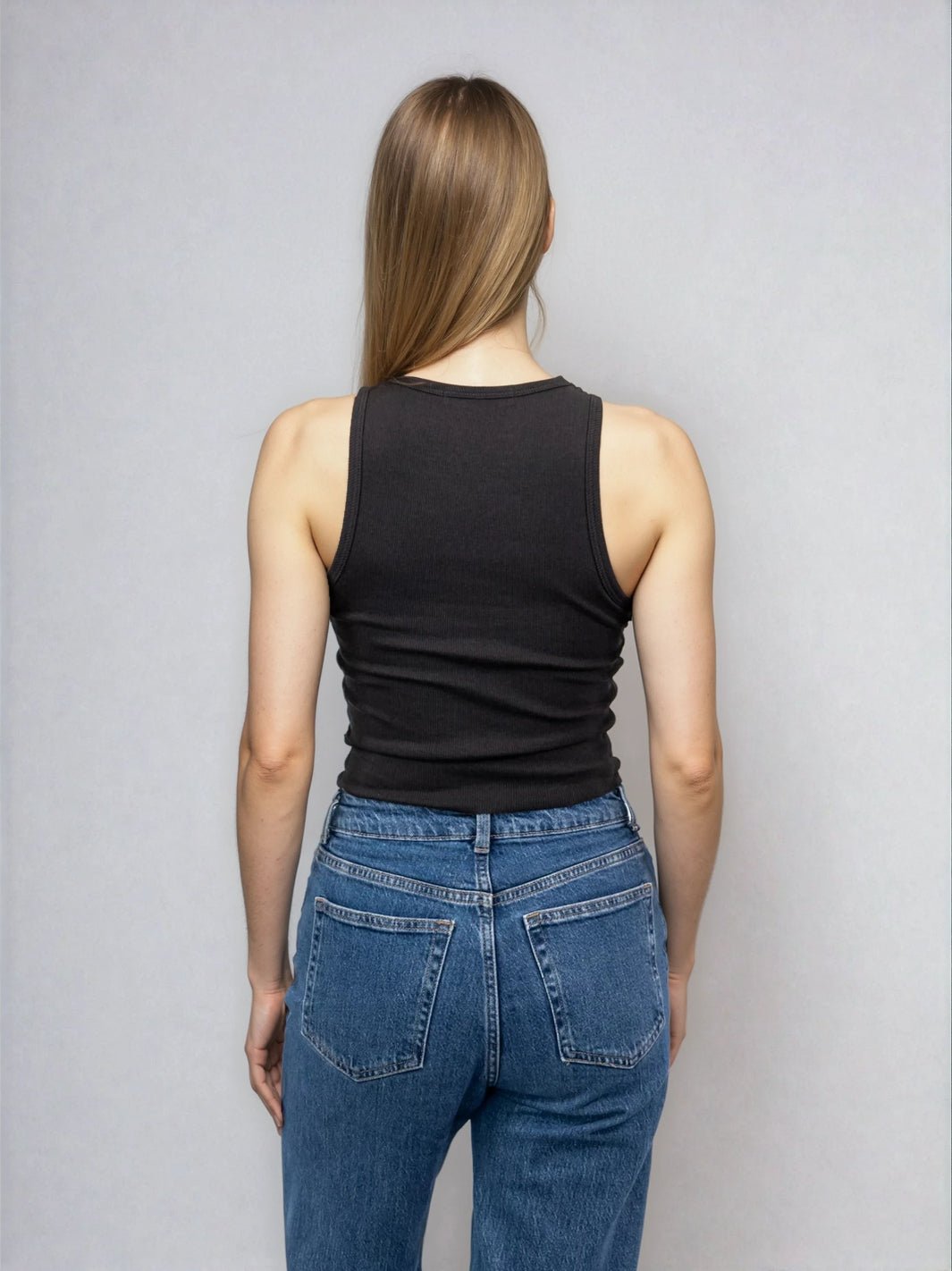Black high-neck sleeveless cropped tank with raw hem, shown from the back view.