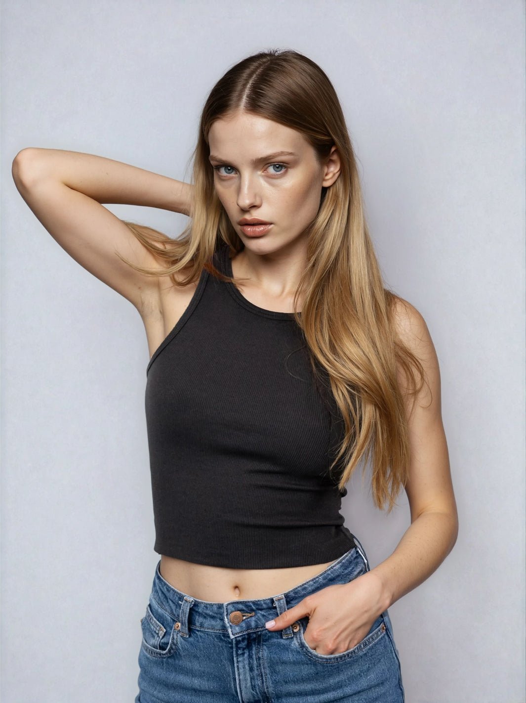 Black high-neck cropped tank with sleeveless cut and raw hem, front three-quarter view.