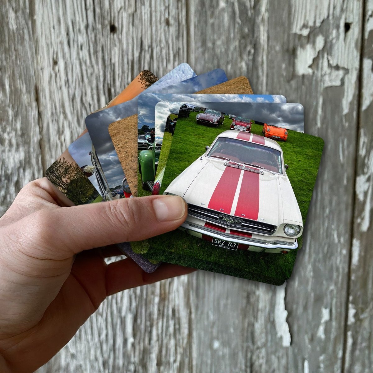 Hand holding a car themed activity card featuring a vintage race car on grass
