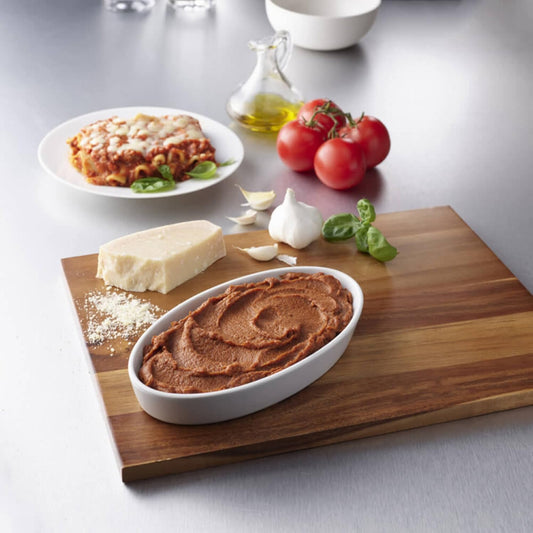 Italian-style lasagna puree in white tray with tomato, garlic, basil, and cheese