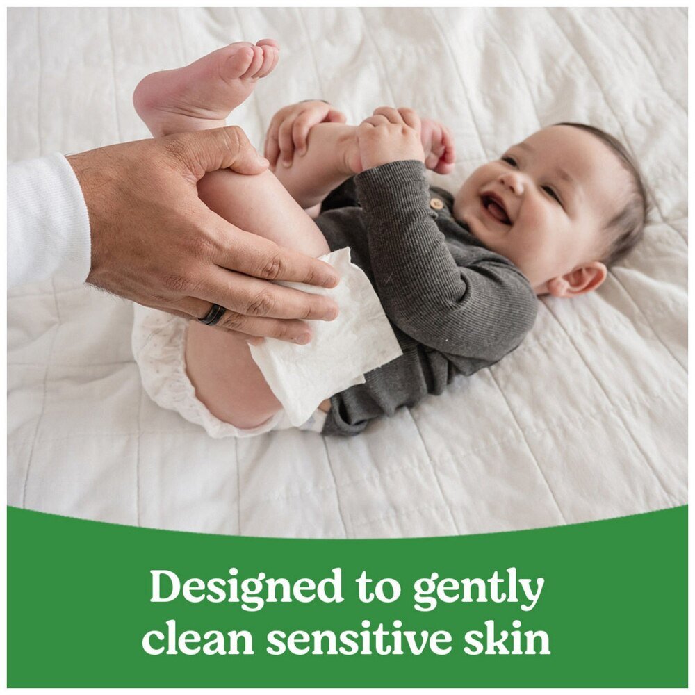 Adult uses fragrance-free baby wipes on a baby’s diaper area
