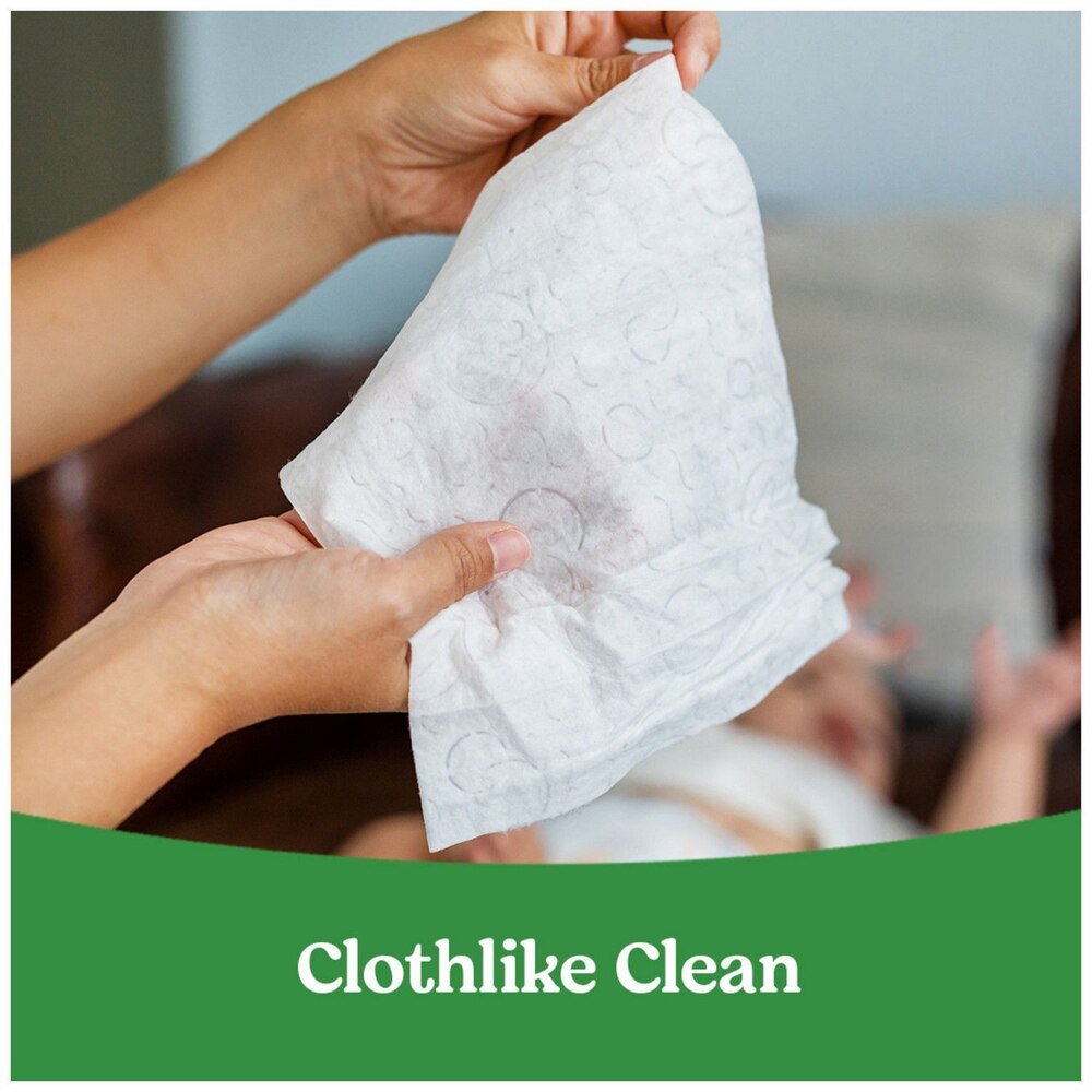 Hands pulling a baby wipe from a dispenser pack; Huggies Natural Care