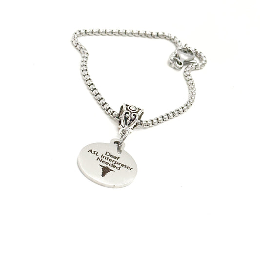Silver bracelet with a heart-shaped tag and decorative clasp on a white background