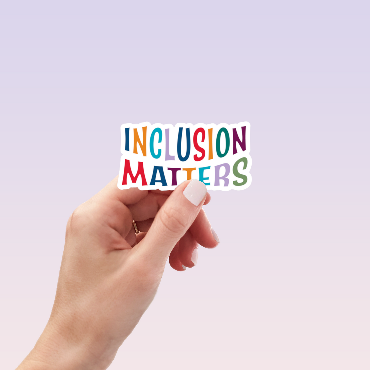 Hand holding white die-cut Inclusion Matters sticker with multicolor letters
