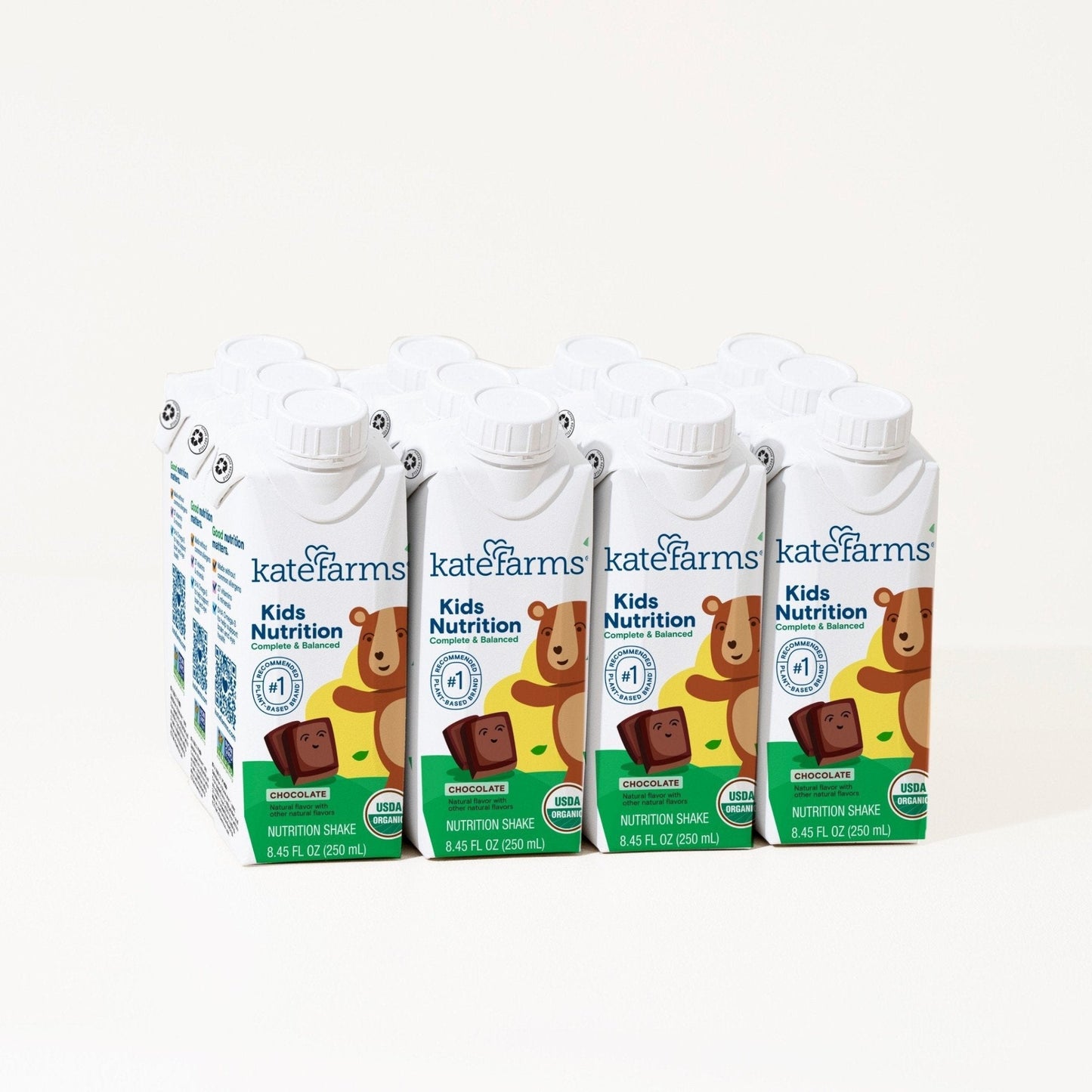 Four chocolate Kids Nutrition shake cartons with white caps in a case
