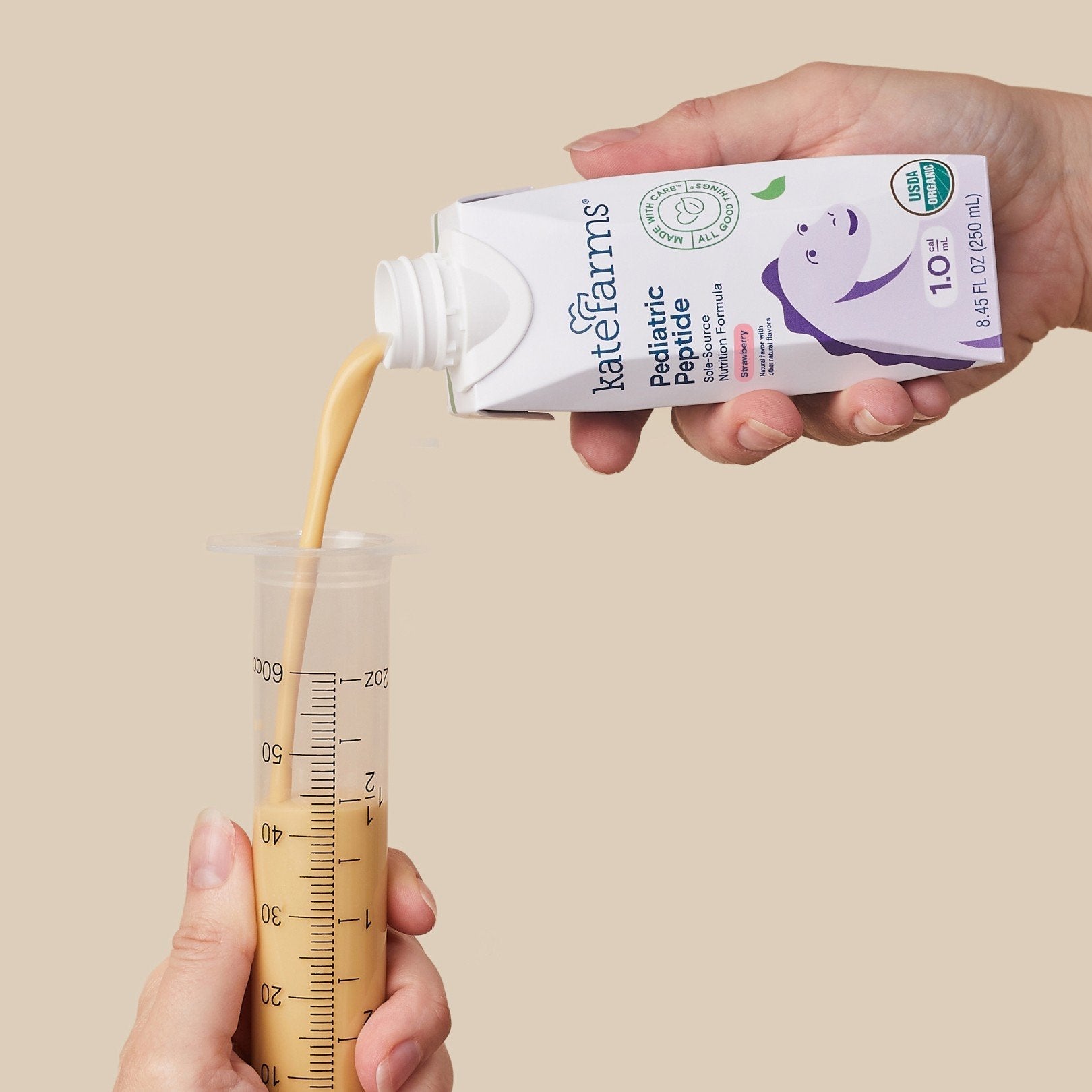 Strawberry Pediatric Peptide 1.0 carton being poured into a measuring cup, 1.0 kcal/mL.