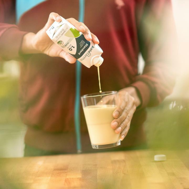 Pouring plain formula into a glass cup, beige-colored shake