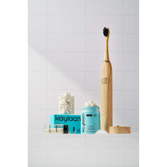Tooth care starter kit with bamboo sonic toothbrush, mint toothpaste container, and tablets