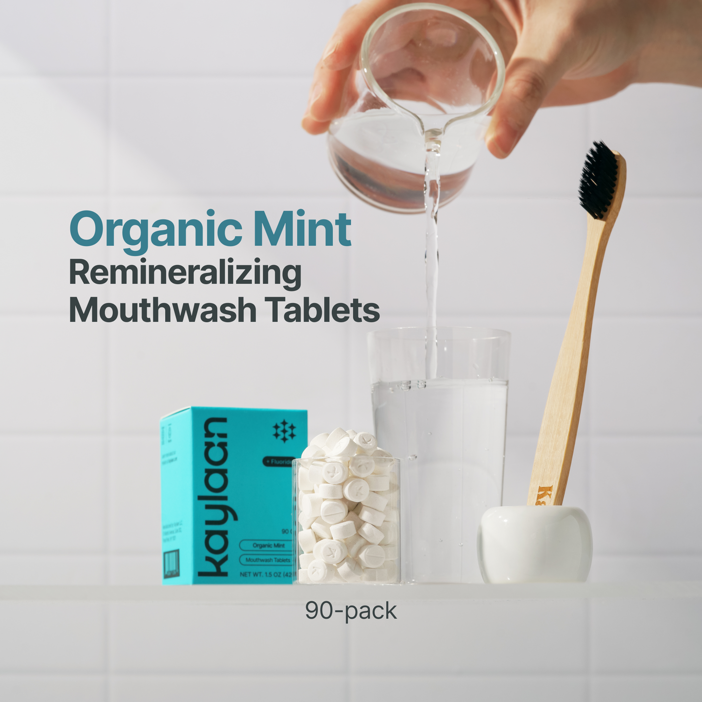 Organic mint mouthwash tablets with teal pack, glass cup, and wooden toothbrush