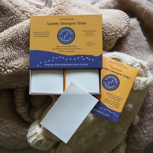 Laundry detergent strips box open with white sheets on display; chamomile